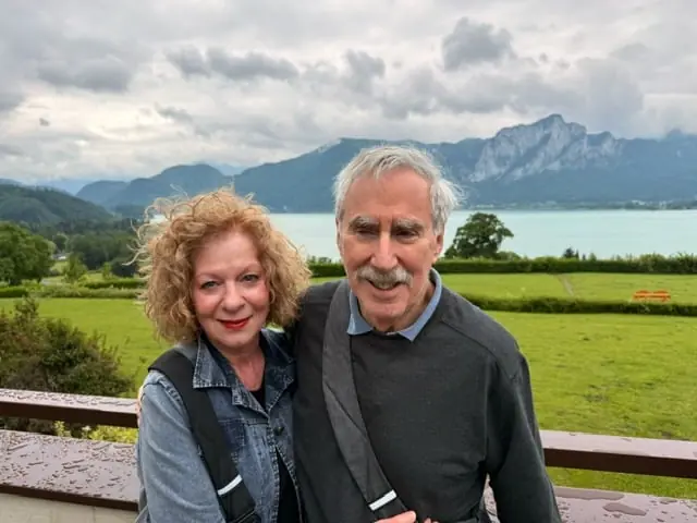 Bob and Ann Quasman smiling together with a lake and mountains behind them