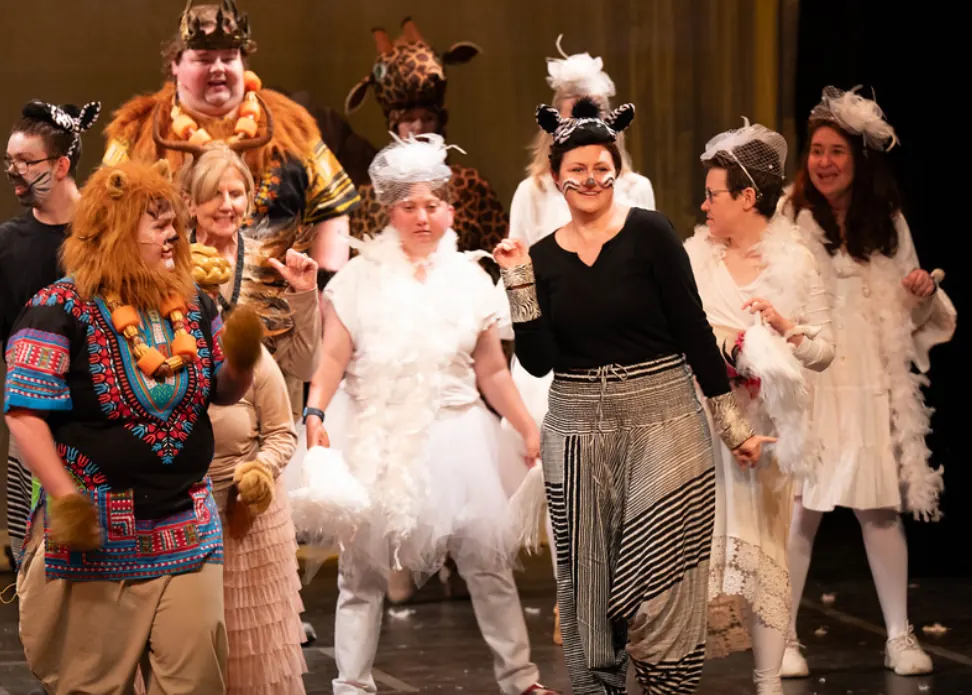 Performers in zebra, lion and bird costumes on stage in the Zack's Place production of The Lion King