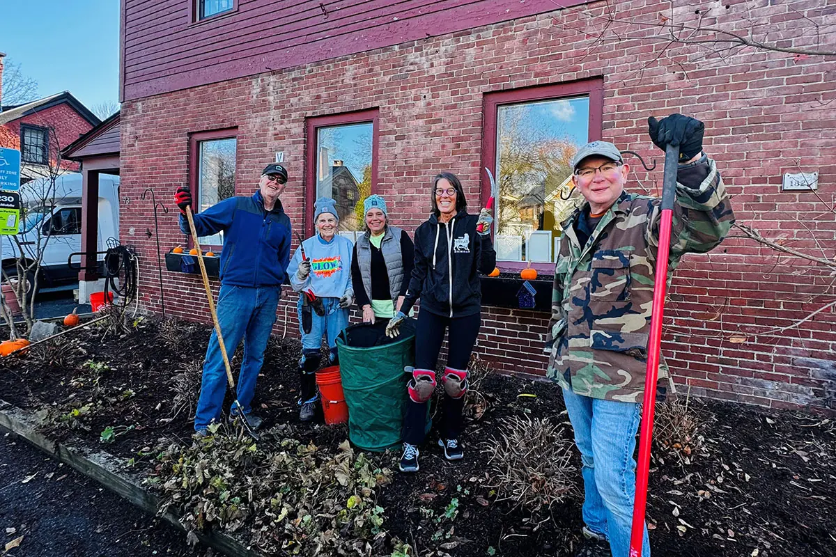 Board members and volunteers cleaning up the garden beds outside Zack's Place